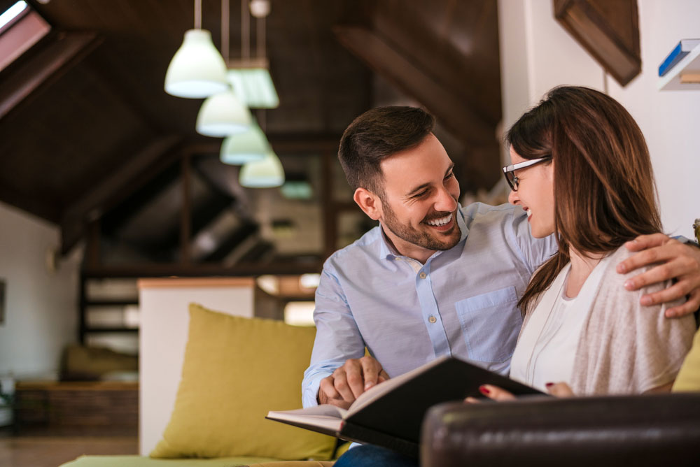 Paradigm Principles Financial Planning - Husband reading a book with his wife